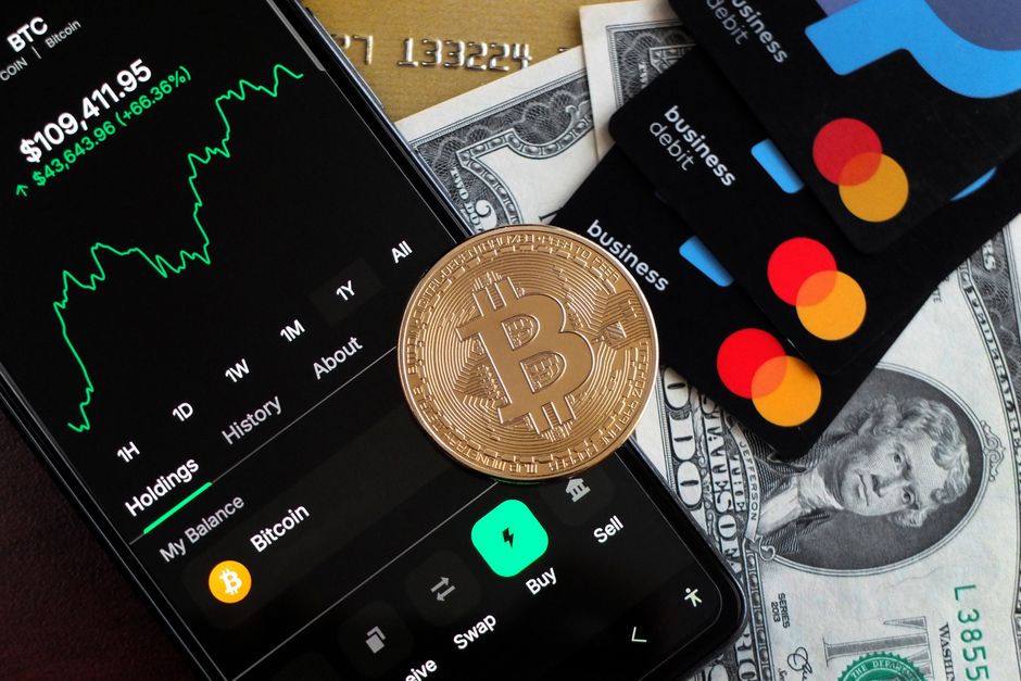 Дебетова картка Krak компанії Kraken на фоні криптовалютних символів